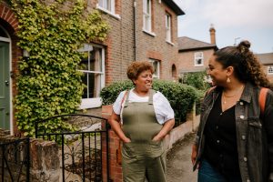 This is an image of an older woman and a younger woman walking on a residential street.