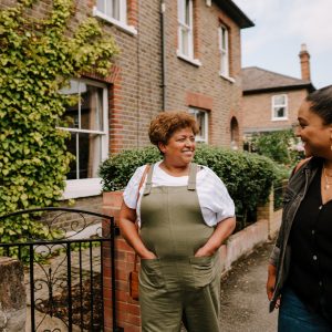 This is an image of an older woman and a younger woman walking on a residential street.