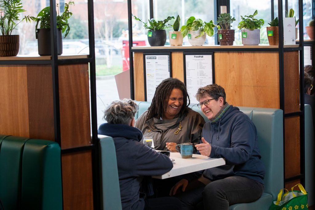 This is an image of three women socialising at a cafe