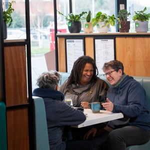 This is an image of three women socialising at a cafe