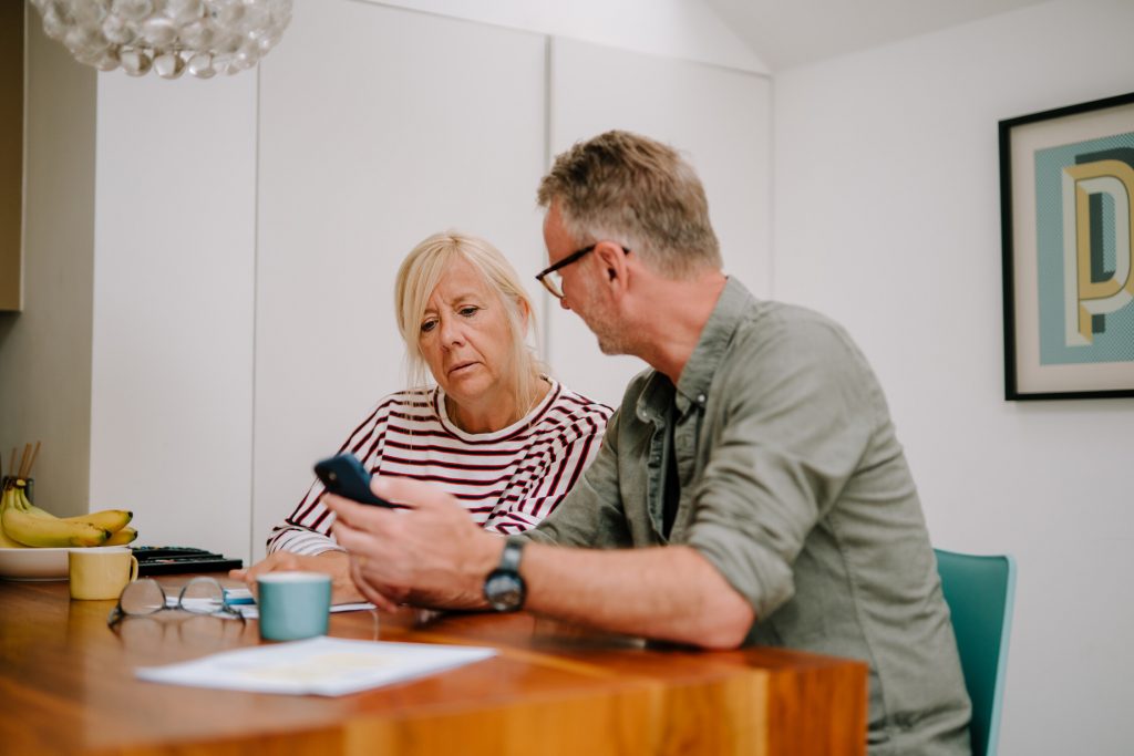This is an image of two people looking at a phone.