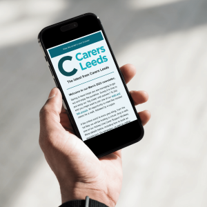This is an image of a phone showing the Carers Leeds newsletter on the screen.