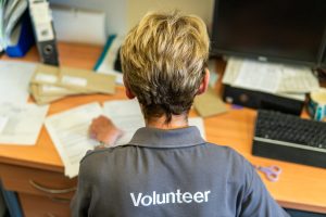 This is an image of a woman with volunteer on her shirt,