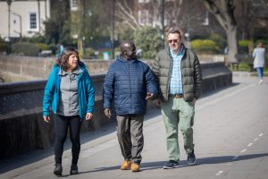 This is an image of three people walking on a path.