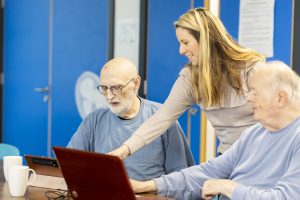This is an image of two men and a woman teaching on a laptop.