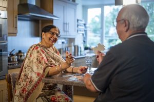 This is an image of a female and male carer playing a puzzle.