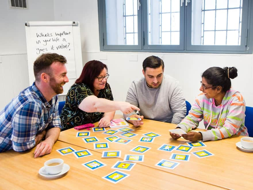 This is an image of four people round a table organising cards.