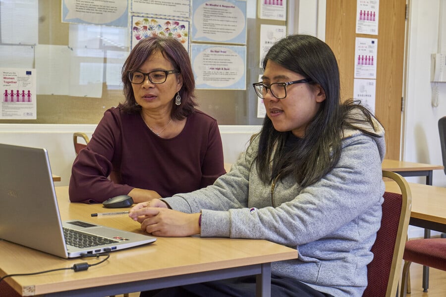 Image of two people looking at a laptop