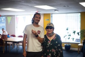 Image of a young male carer and the person he cares for, an older woman