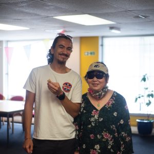 Image of a young male carer and the person he cares for, an older woman